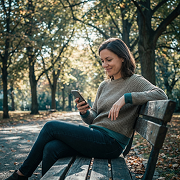 Frau verwaltet ihre Energiegemeinschaft bequem per Smartphone im Park
